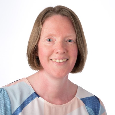 Woman with short hair smiling against plain white background